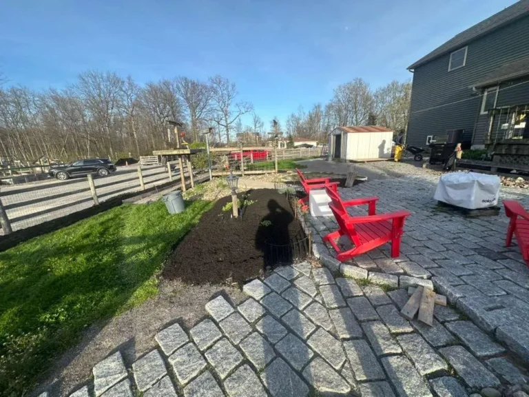 Cobblestone paver patio with red Adirondack chairs