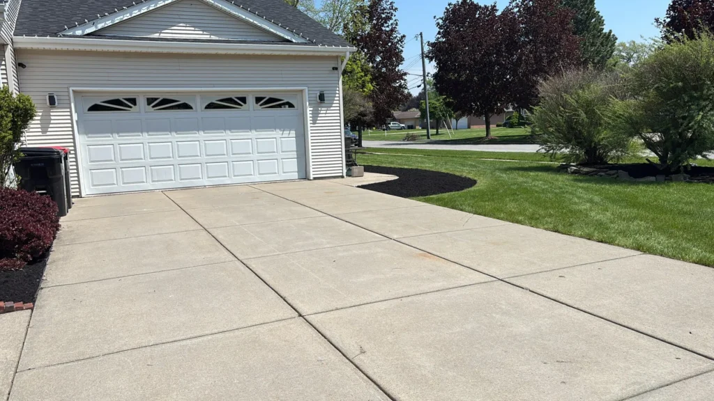 Clean driveway edge with mulch bed and lawn in Buffalo NY