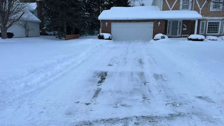 Snow plowed driveway in front of a garage in Buffalo NY