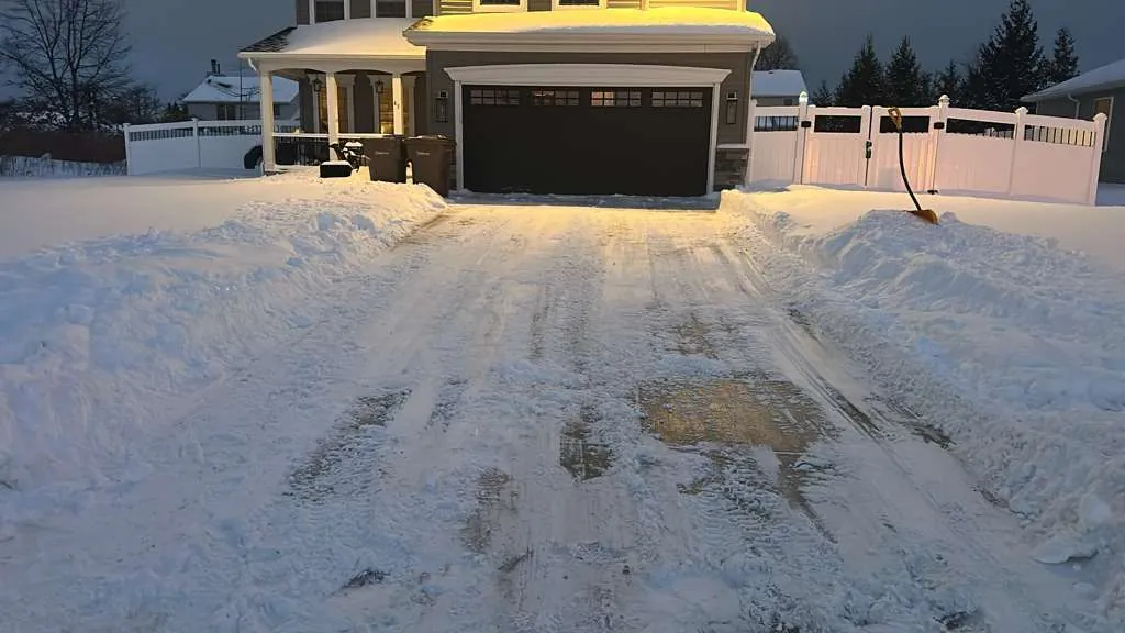 Plowed residential driveway at night after a Buffalo snowfall