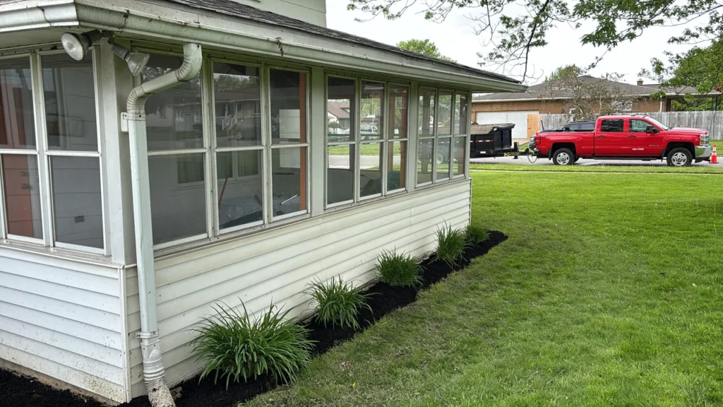 Sunroom porch with a fresh foundation planting bed